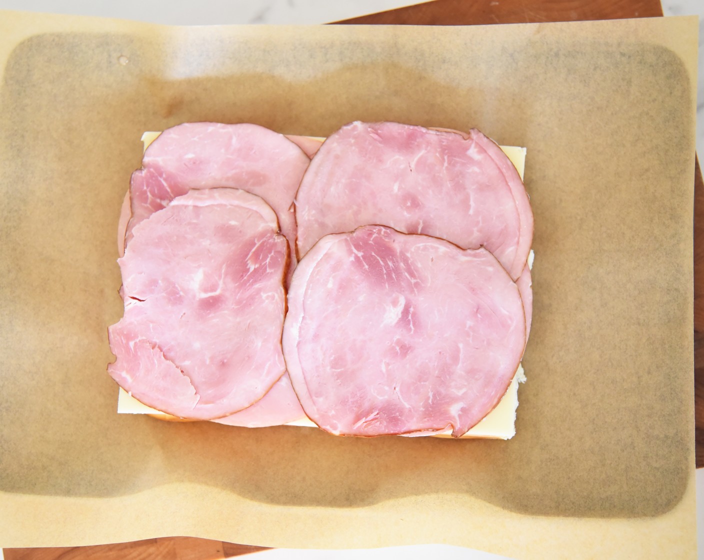 step 5 Lay the Deli Ham (8 oz) evenly on top of the Swiss cheese slices.