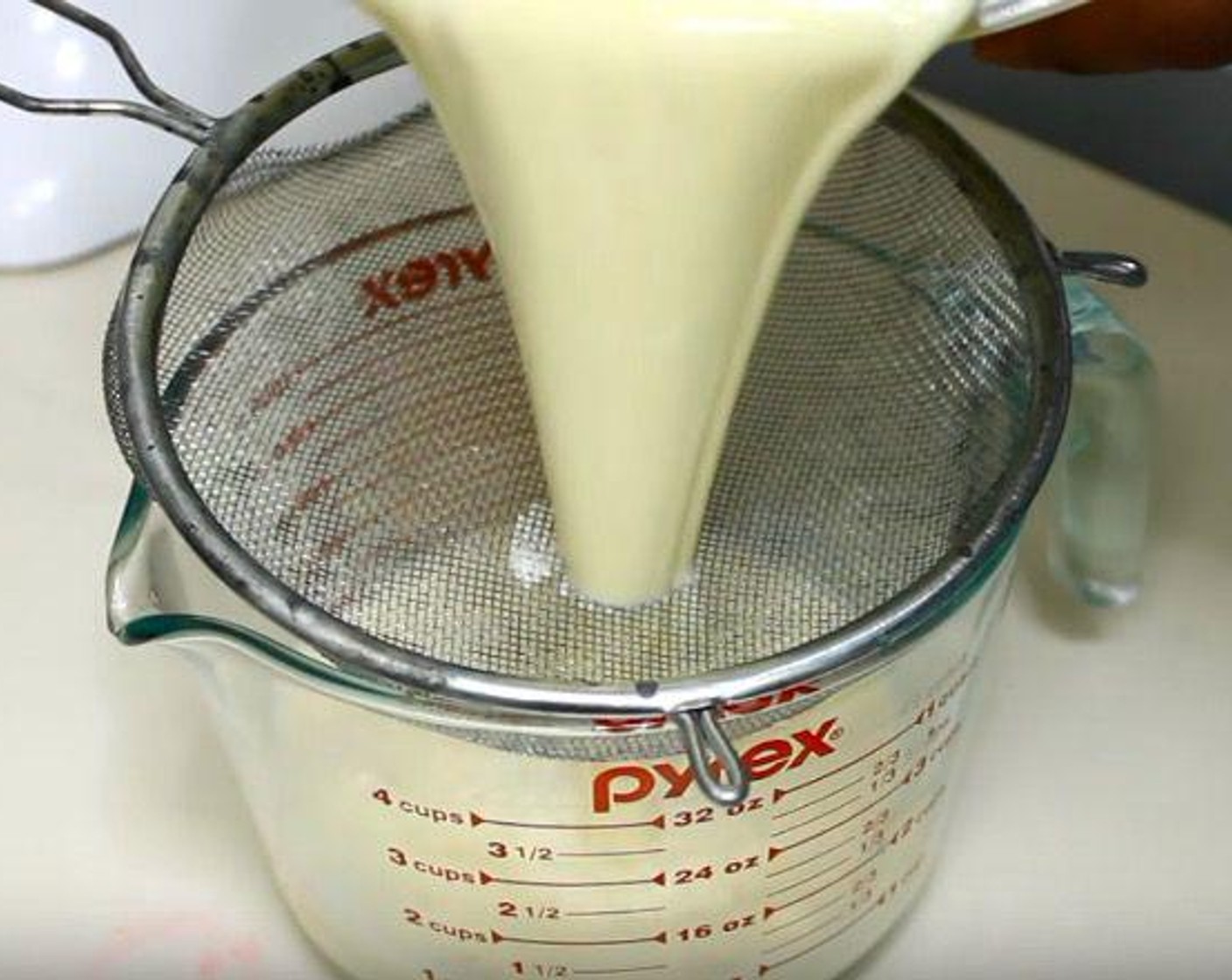 step 3 Add the heavy cream mixture very slowly to the egg mixture, whisking as you go. Pass the cream through a strainer into a clean mixing jug. Use a spoon to skim any bubbles from the top of the mixture.