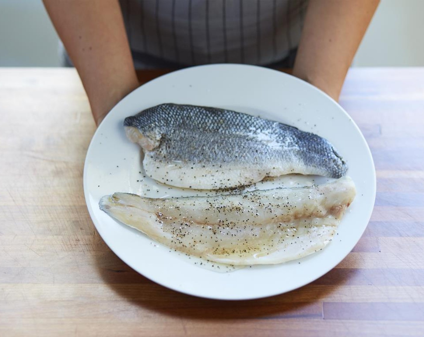 step 3 Pat dry the Branzino Fillets (2) with paper towels. Rub both sides of the fish with Vegetable Oil (as needed) and season with Salt (1/2 tsp) and Ground Black Pepper (to taste).