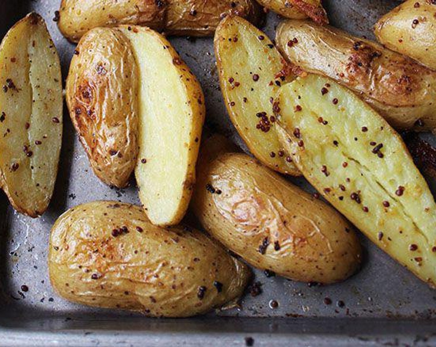 step 2 Cut the Fingerling Potatoes (6 cups) in half lengthwise and place them on a sheet pan. Add Extra-Virgin Olive Oil (2 Tbsp), Kosher Salt (1 tsp), Freshly Ground Black Pepper (1/4 tsp), and the Whole Grain Mustard (2 Tbsp) to the potatoes, and toss well with your hands to coat.