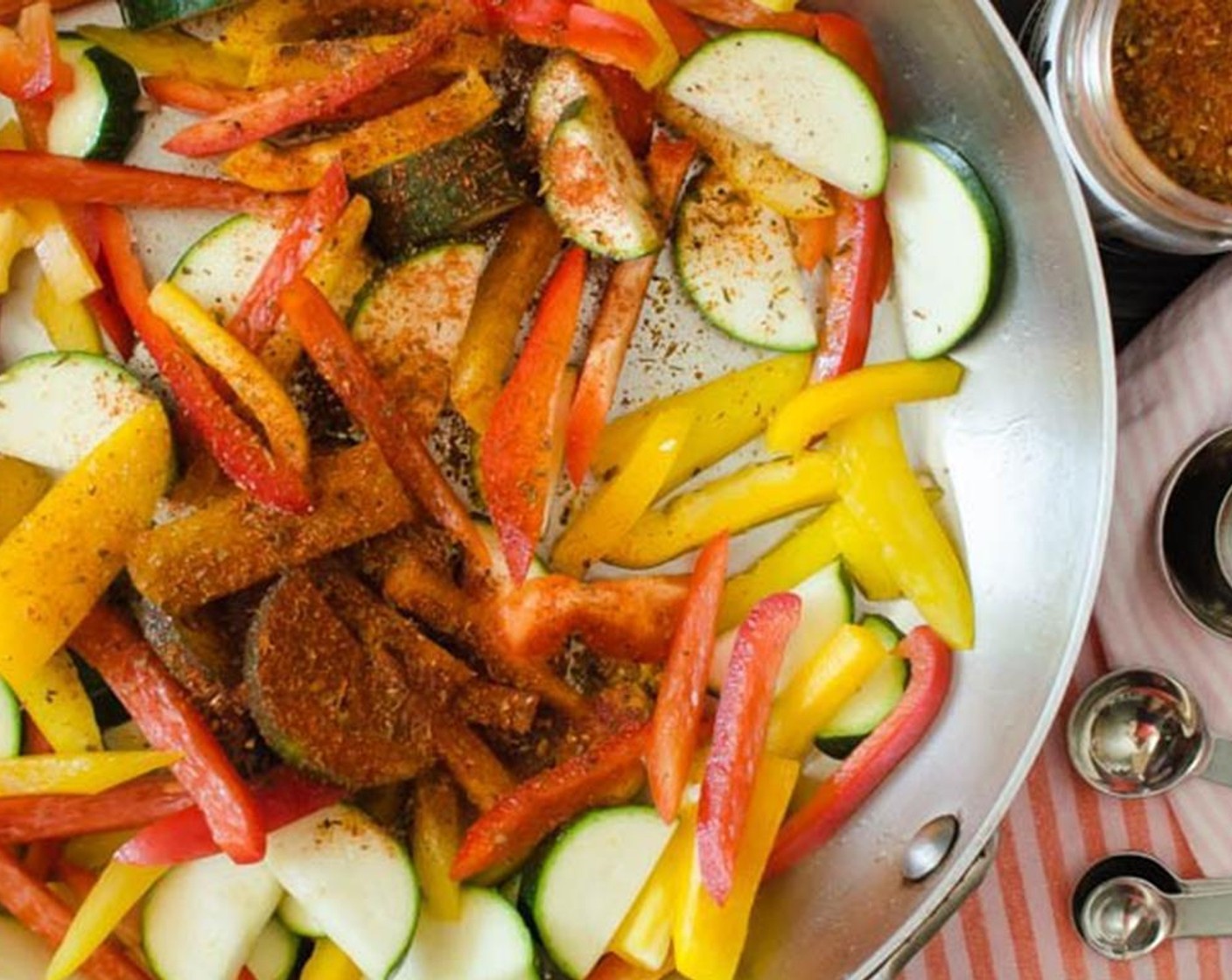 step 4 In a large skillet, heat Canola Oil (as needed) over medium-high heat. Add the Red Bell Pepper (1), Yellow Bell Pepper (1), Zucchini (1), and sauté for 1-2 minutes.