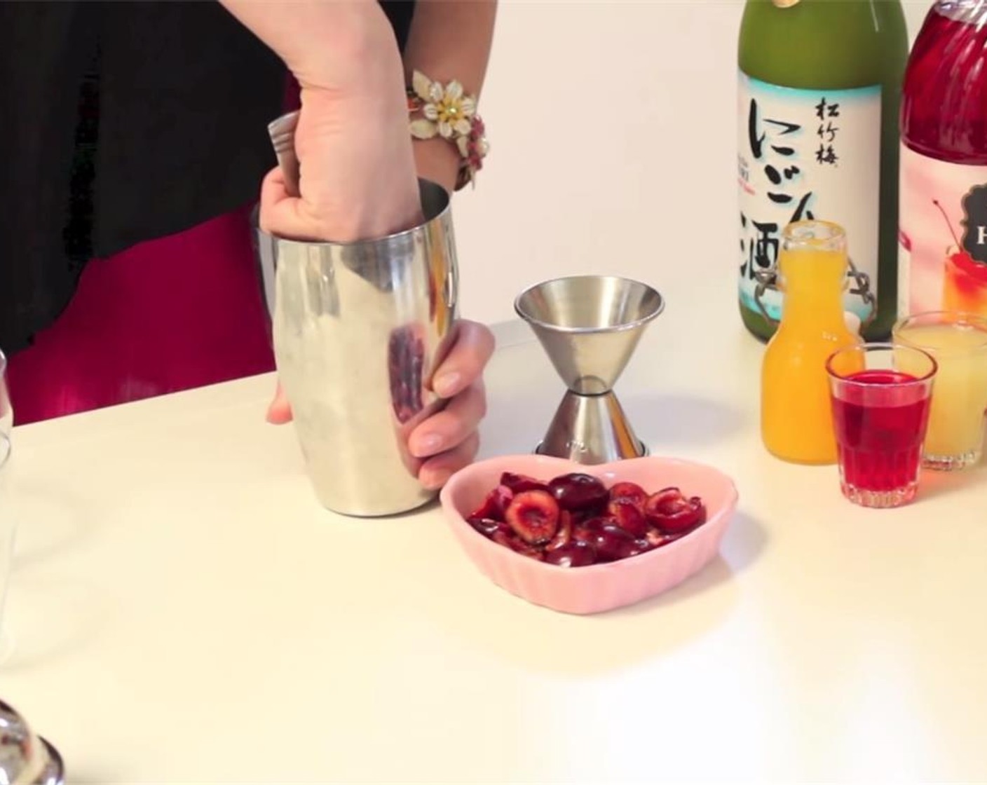 step 1 Pit the Cherries (3) and muddle with the Grenadine Syrup (0.3 fl oz) in a shaker tin. Add Nigori Sake (2 fl oz), GREY GOOSE® Vodka (1 fl oz), juice from Orange (1), juice from Lemon (1), Almond Extract (1 dash), and some Ice (to taste).