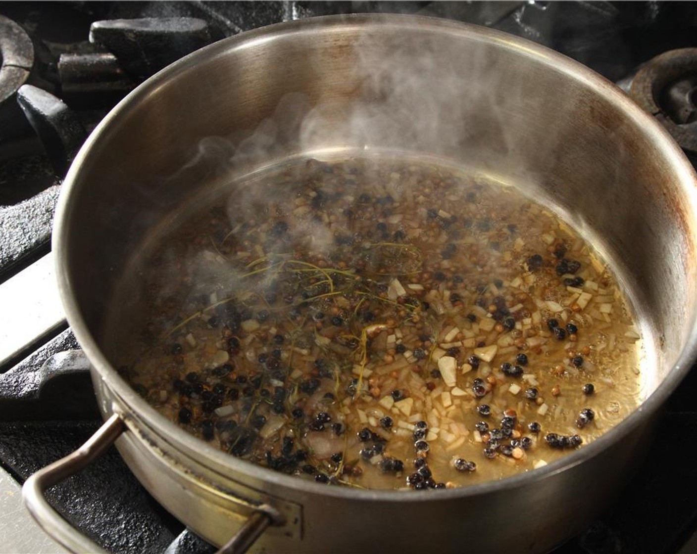 step 8 Combine the diced shallots with the White Wine (3 cups), Fresh Thyme (1 tsp), Black Peppercorns (1 tsp), and Whole Coriander Seeds (1 tsp) in a saucepan and reduce until nearly dry, should take about 15 minutes over low heat.