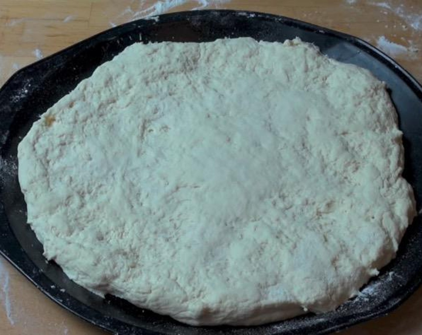 step 2 On a floured surface, knead the dough until smooth. Roll it out into a large, round shape. Transfer dough onto baking tray.