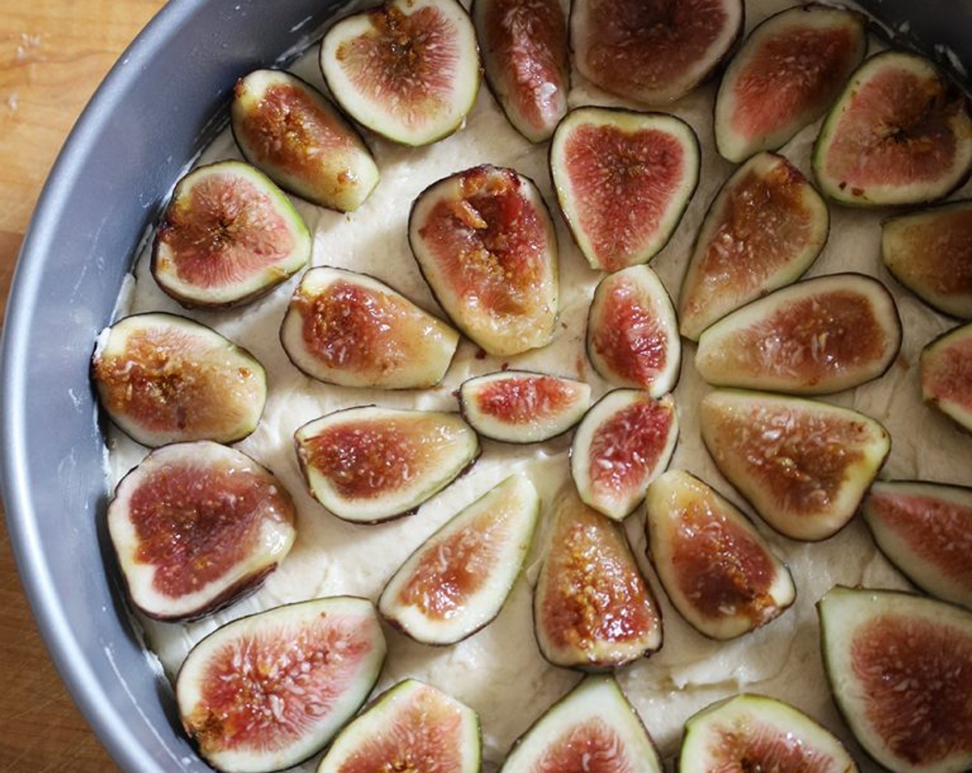 step 9 Arrange the figs, cut sides up, on the cake in concentric circles. Place the cake on a sheet pan.
