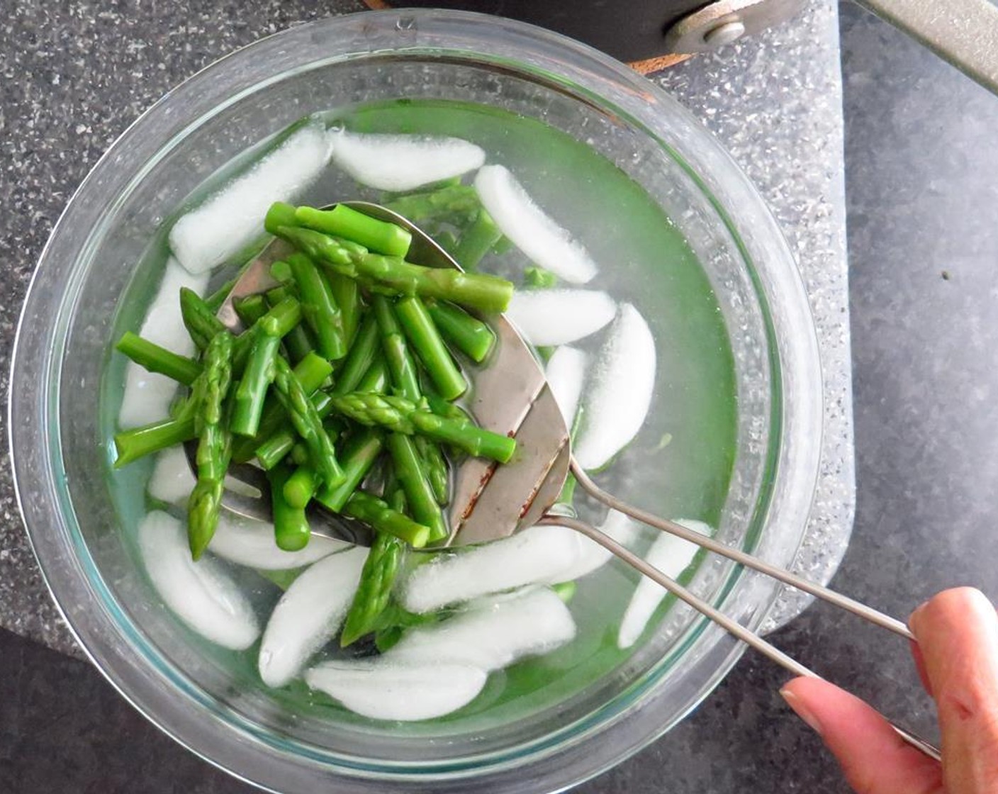 step 4 Using a slotted spoon, scoop out the asparagus and plunge into ice bath to stop the cooking and set color. Remove asparagus and pat dry with a paper towel.