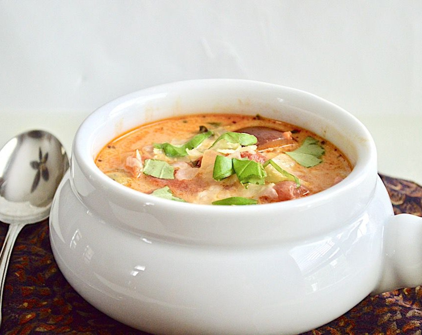 step 8 Take it off the heat and ladle the soup into pretty bowls. Top each bowl with grated parmesan and chopped basil, and serve immediately with crusty bread for dipping! Enjoy! It also makes fantastic leftovers since this recipe makes a lot.