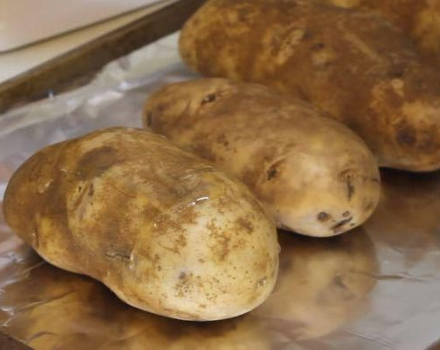 step 1 Wash the Russet Potatoes (4) and dry it with a paper towel. Then brush with Oil (as needed). Bake at 400 degrees F (200 degrees C) for an hour.