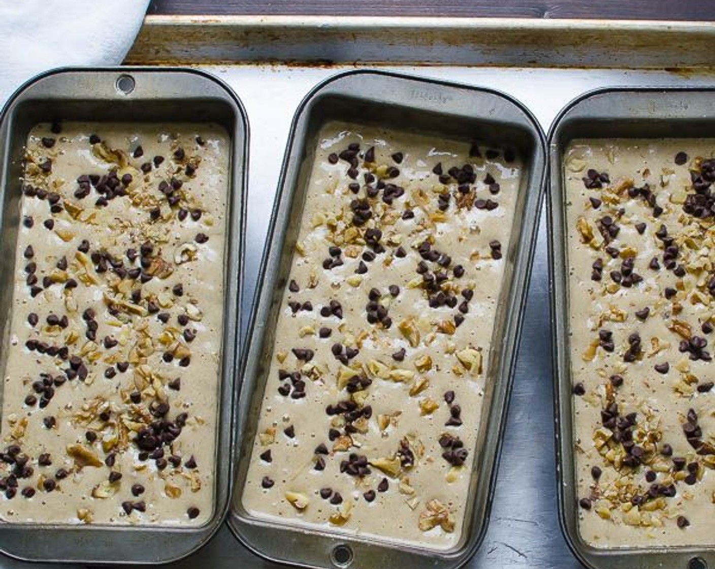 step 7 Spoon batter evenly into the loaf pans. Divide the Semi-Sweet Mini Chocolate Chips (1/4 cup) and Walnut (1/4 cup) over the top of the three loaves.