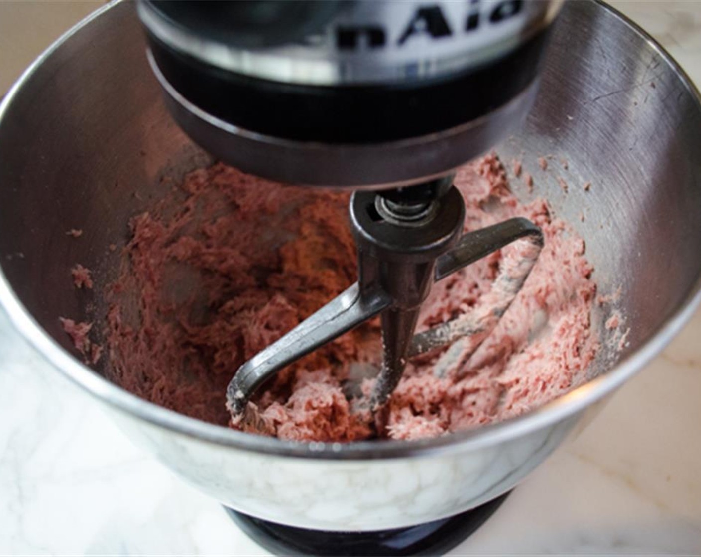 step 4 In a stand mixer fitted with the paddle attachment, beat the Ground Pork (8 oz), Garlic (1 clove), Ground Allspice (1/8 tsp), Ground Black Pepper (1/8 tsp), Salt (3/4 tsp), and Baking Powder (1 tsp) on high speed until smooth and pale, about 2 minutes, scraping bowl as necessary.