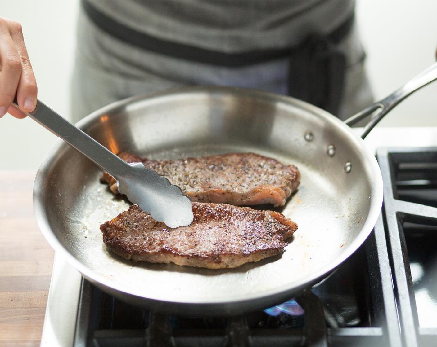 step 7 Heat a medium sauté pan over high heat and add Olive Oil (2 Tbsp). When hot, add the steaks and sear for 2 minutes. Turn over and sear for 2 minutes more.