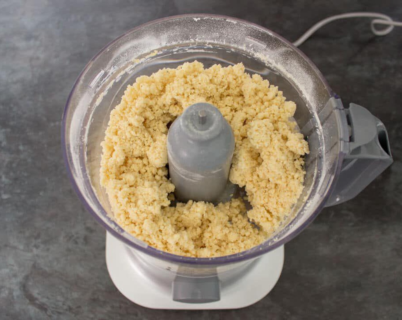 step 2 Add the Egg (1) with Water (1 Tbsp) and gradually pour it into the food processor whilst it’s still on. Stop when the pastry starts to clump together. If necessary, add a little more water.