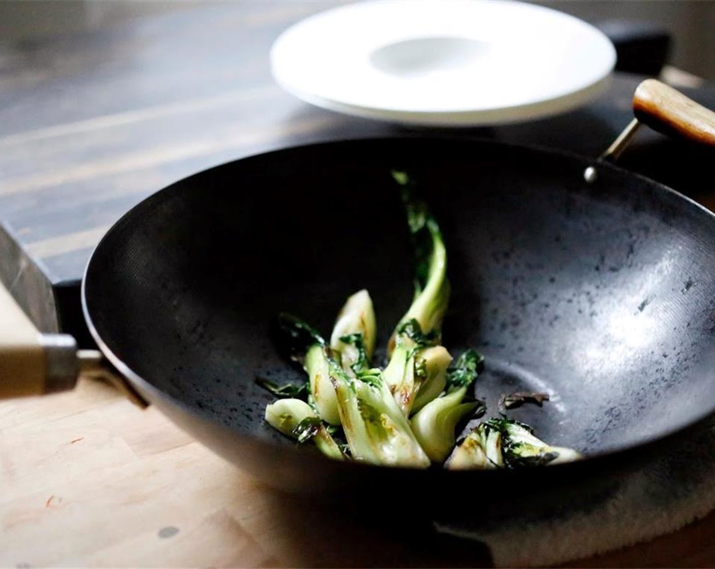 step 16 Heat oil in a wok or skillet over medium high heat. When hot, add baby bok choy, turning occasionally, until wilted, about 4 minutes.  Add a couple tablespoons of the fish marinade, tossing to coat, letting the marinade cook and reduce.