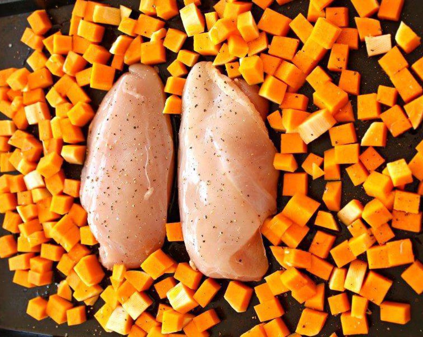 step 2 Place the Boneless, Skinless Chicken Breasts (2) on a baking sheet and brush with Salt (1/4 tsp) dissolved in Water (1 1/2 Tbsp), place the Butternut Squash (1/2) around the chicken, drizzle the butternut with a little Olive Oil (1 dash) and season with Salt (to taste) and Ground Black Pepper (to taste).