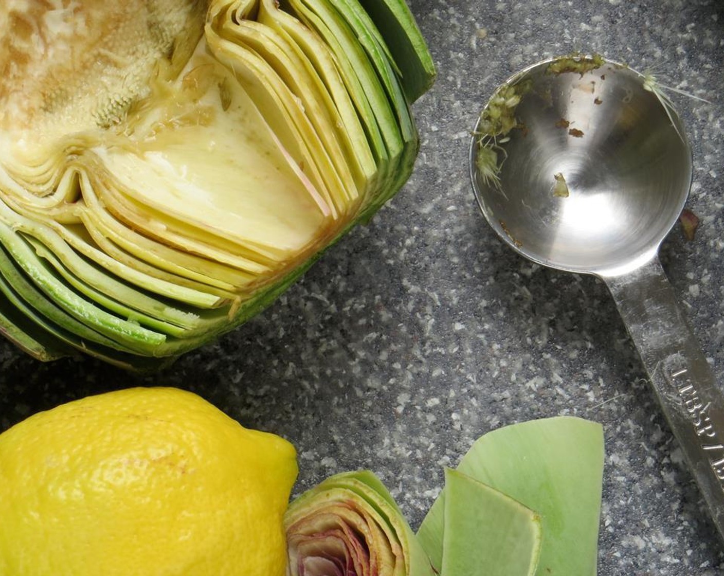 step 5 Use a spoon to remove the hairy choke and purple interior. Rub or squeeze juice from the Lemon (1) over the interior of the artichoke to prevent browning. Continue with the remaining artichoke halves.