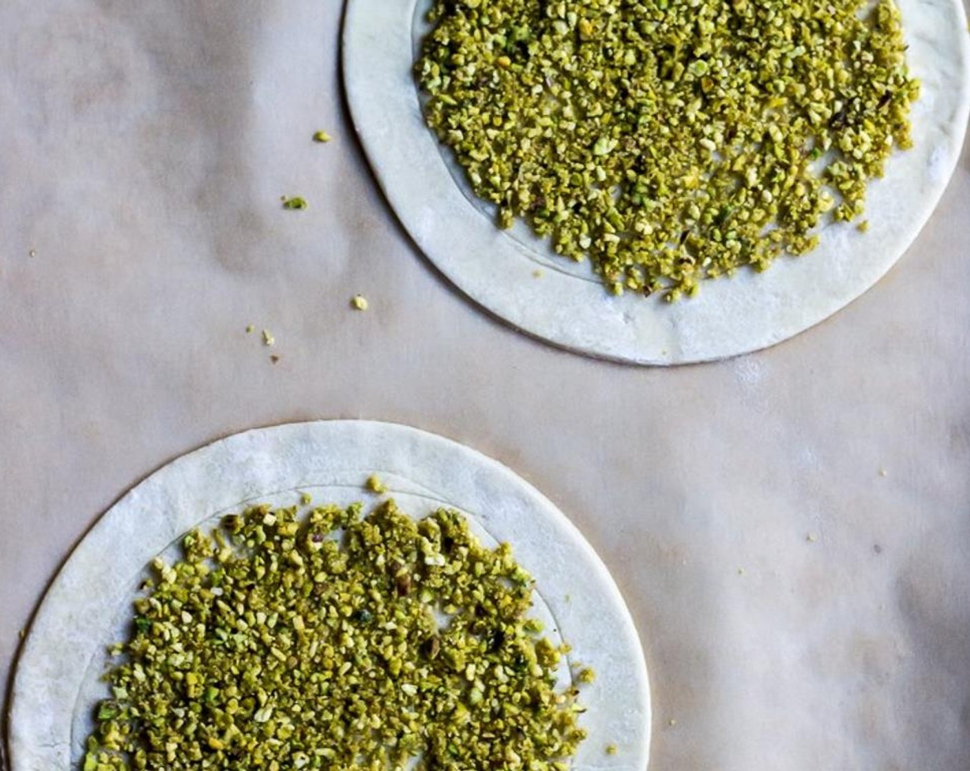 step 9 Evenly divide the ground pistachio blend onto the four pastry rounds, spreading it evenly across the inner circle of your puff pastry rounds.