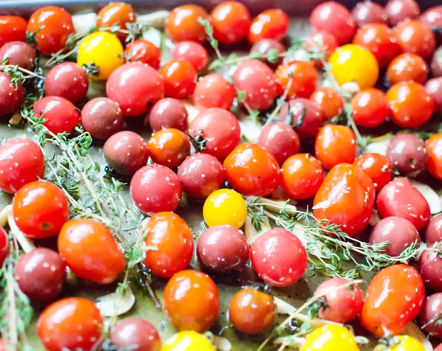 step 2 Spread Cherry Tomatoes (9 cups) onto a large rimmed baking sheet. Add Extra-Virgin Olive Oil (3/4 cup), Kosher Salt (1/2 Tbsp), Freshly Ground Black Pepper (1 tsp), and Garlic (10 cloves); toss gently to coat. Tuck Fresh Thyme (8 sprigs) into the mixture.