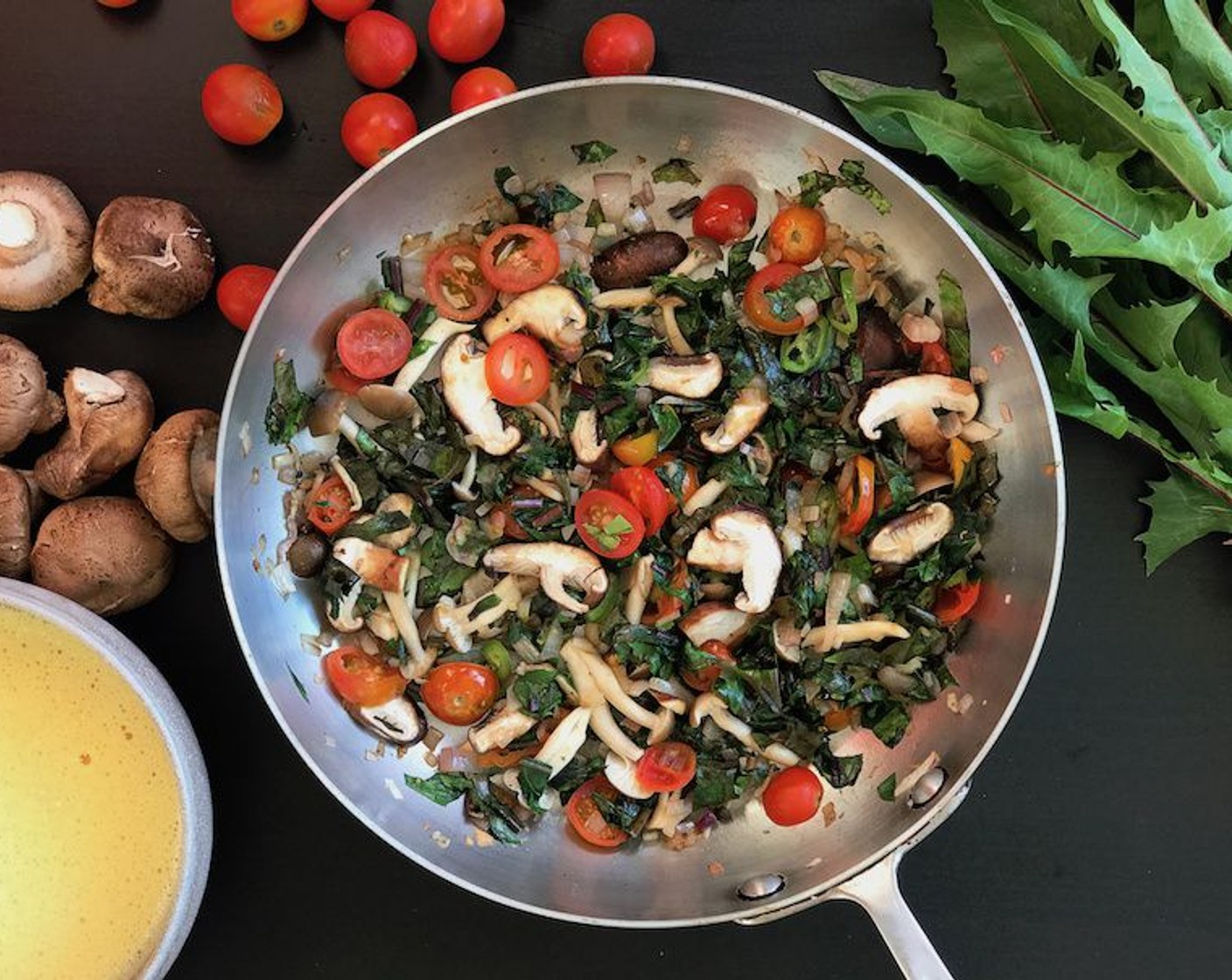 step 5 Add the Dandelion Greens (1 bunch), Cherry Tomato (1 handful), and Serrano Chili (1). Sautee until greens wilt, 1-2 minutes. Make sure there is enough oil/butter in the pan so the eggs won't stick.