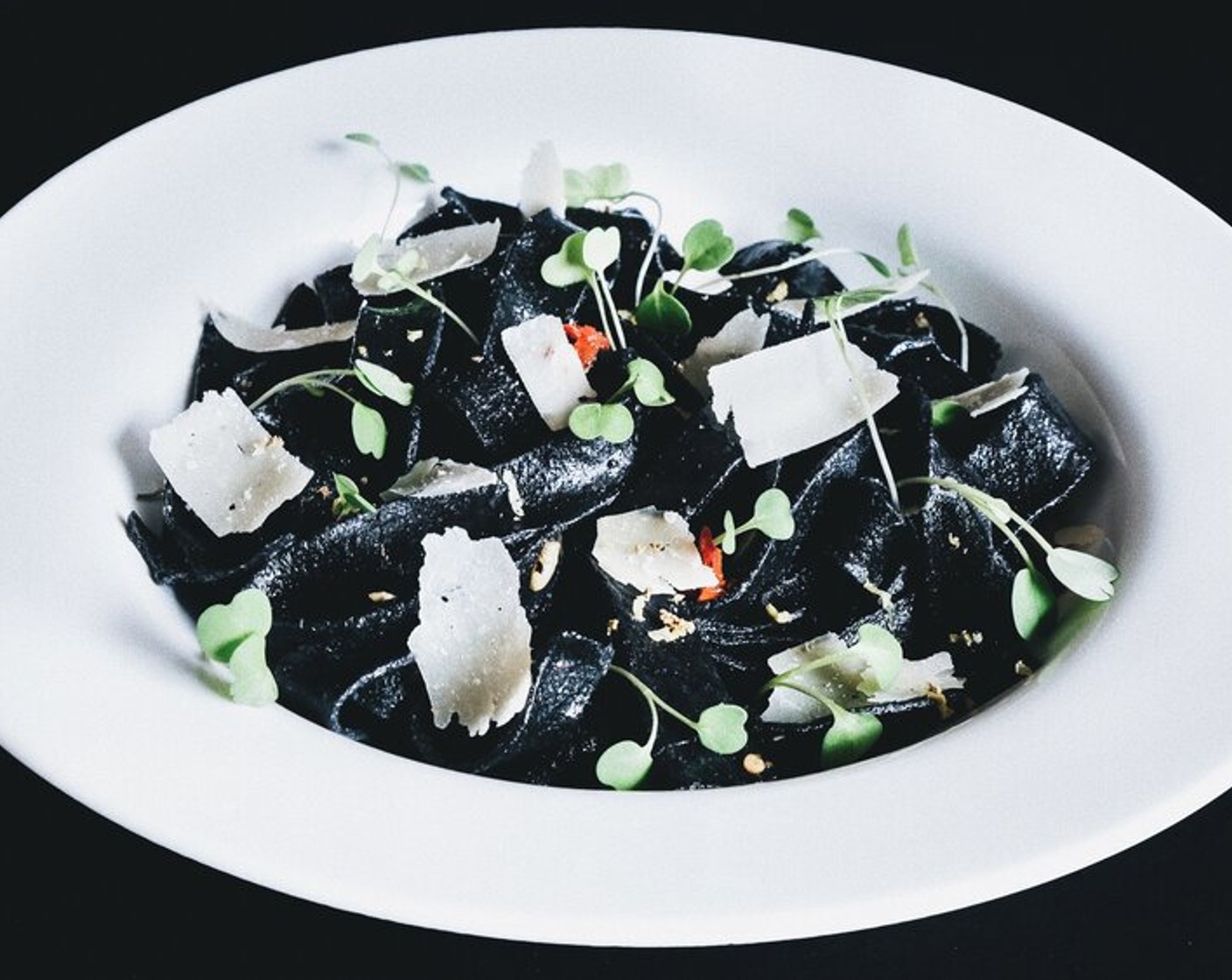 step 4 Serve the pasta while hot and garnish with Shaved Parmesan Cheese (to taste), Microgreens (to taste), and 1 Tbsp of lemon zest. Dig in and devour the dark strands!