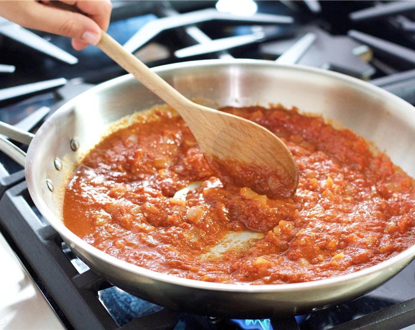 step 7 Add the Crushed Tomatoes (1 can) and Tomato Paste (2 Tbsp) to the pan, stir, and cook for five minutes.