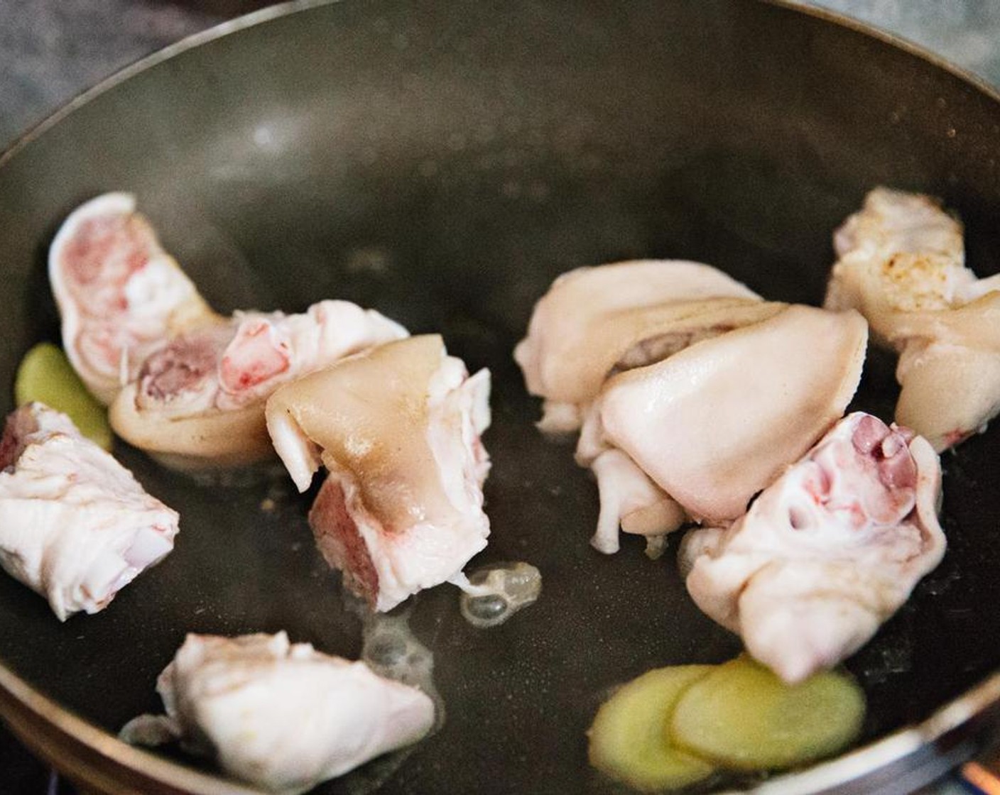 step 2 Add the cleaned pig foot, Water (to taste), ginger slices, and Cooking Wine (1 tsp) into a pot, after the water boils, take the pig foot out.