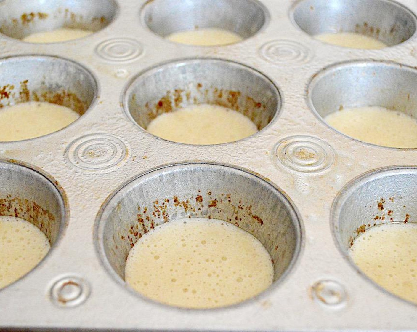 step 5 Scoop a tablespoon of the dough into the wells of the tin. There will be enough for 10. Make sure they are even, then bake the cakes for 8-9 minutes.