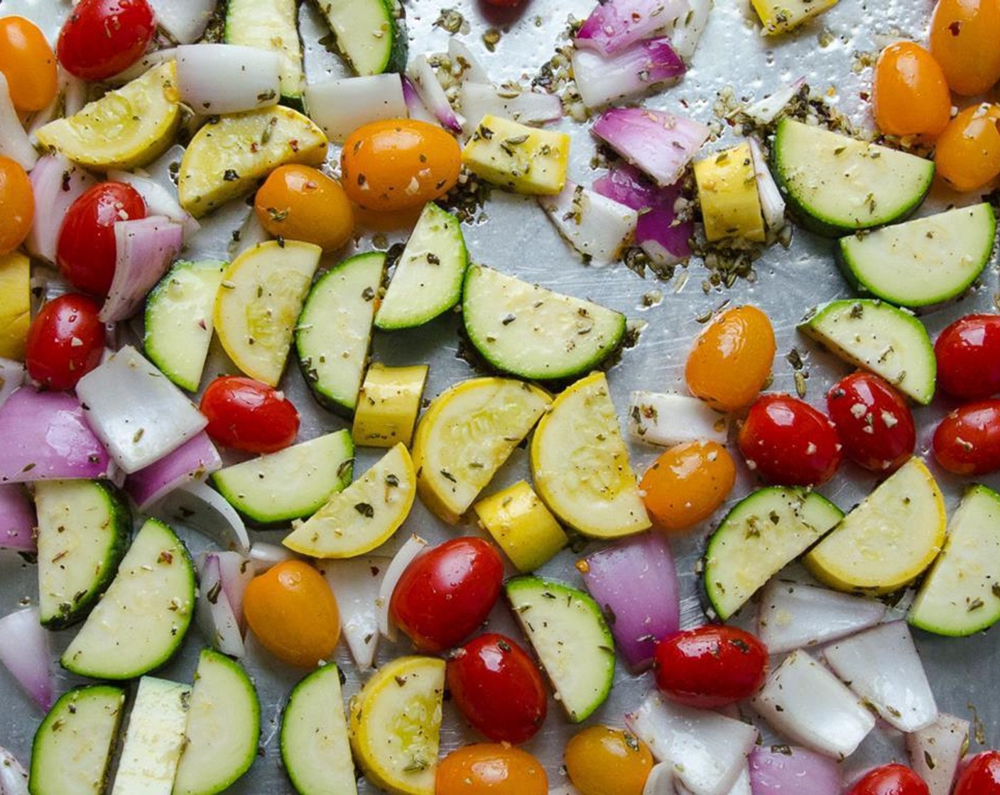 step 4 On a large baking sheet combine the Zucchini (1), Yellow Squash (1), Red Onion (1), Grape Tomatoes (3 cups), Garlic (3 cloves), Dried Basil (1 tsp), Dried Oregano (1 tsp), Crushed Red Pepper Flakes (1/4 tsp), Olive Oil (3 Tbsp), Kosher Salt (1/2 tsp) and Ground Black Pepper (1/2 tsp). Toss to combine.