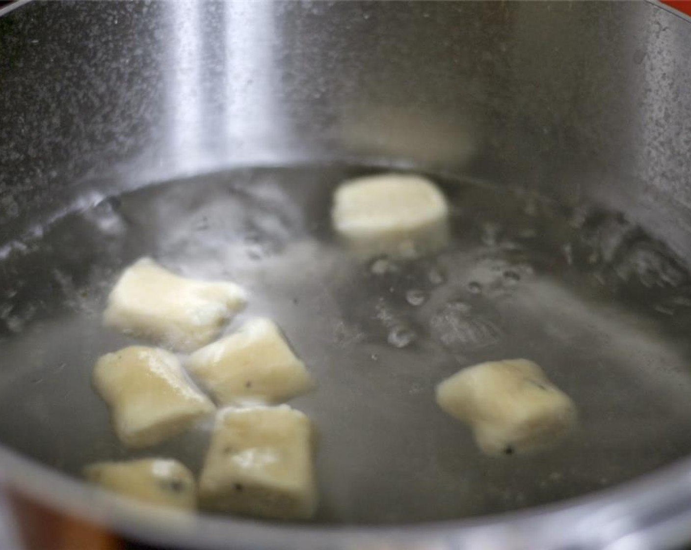 step 8 Working in batches, add some of the gnocchi to the boiling water. Once they float to the surface, let them cook an additional 3 to 4 minutes. Remove gnocchi with a slotted spoon or skimmer and transfer to a colander set over a bowl.