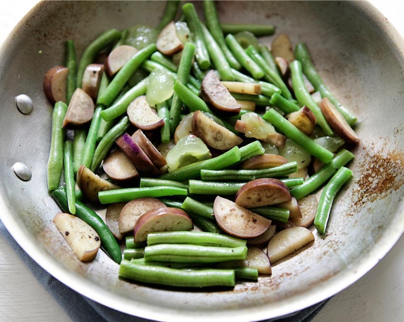 step 7 Heat a large saute pan over medium-high heat. Add half of the Vegetable Oil (2 Tbsp) along with the chilis (optional) and Japanese Eggplants (2). Cook while stirring for 2-3 minutes. Add Green Beans (1 1/2 cups) and continue to cook and stir for 5-6 minutes.