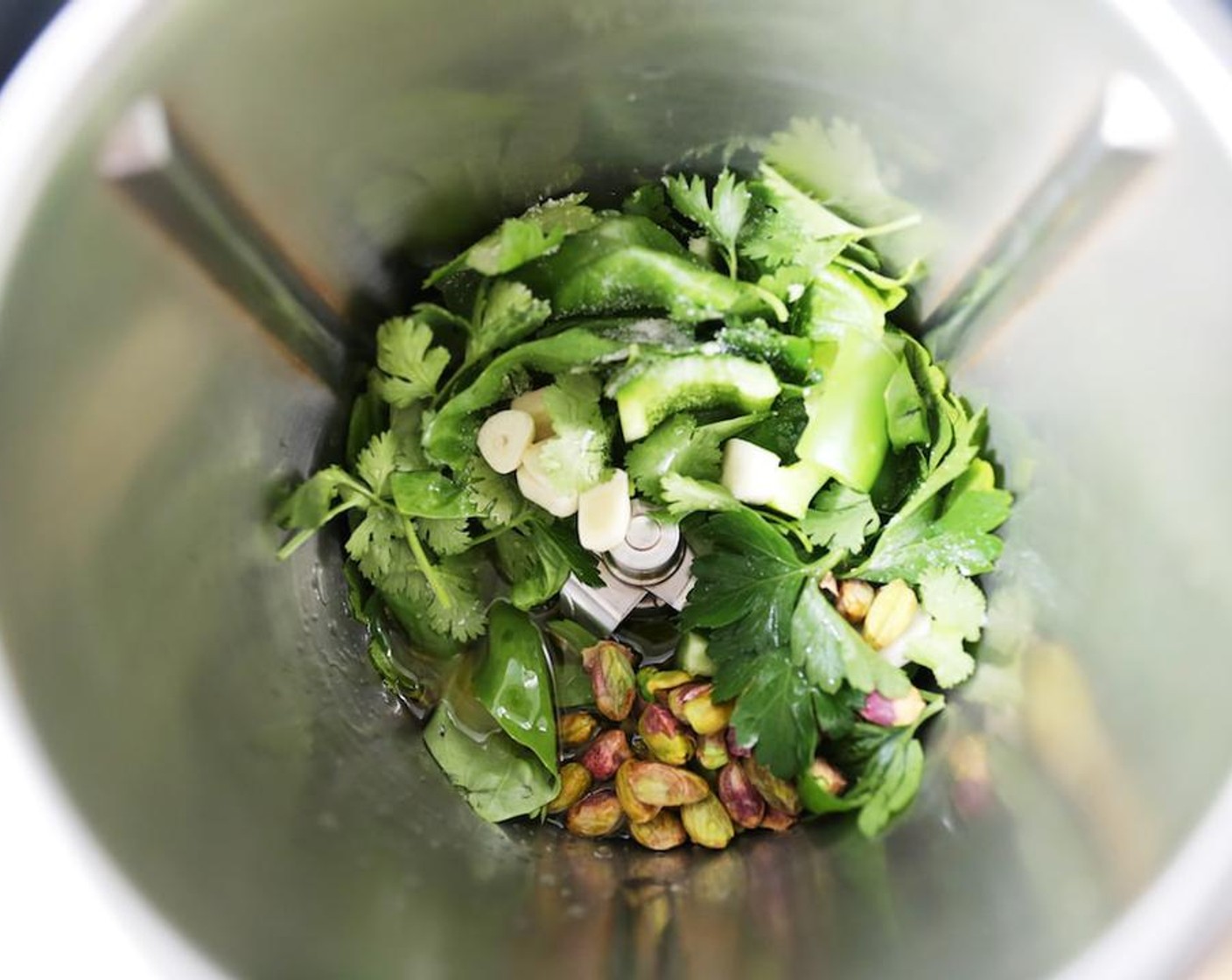 step 3 Place the Fresh Cilantro (2 cups), Fresh Parsley (3/4 cup), Fresh Basil (1 cup), Green Bell Pepper (1/2 cup), Garlic (2 cloves), Salt (1 tsp), Water (2 oz), Olive Oil (3 oz), Pistachios (4 Tbsp) and the juice from Lemon (1) in the jug and blend on speed 5 for 1 minute.