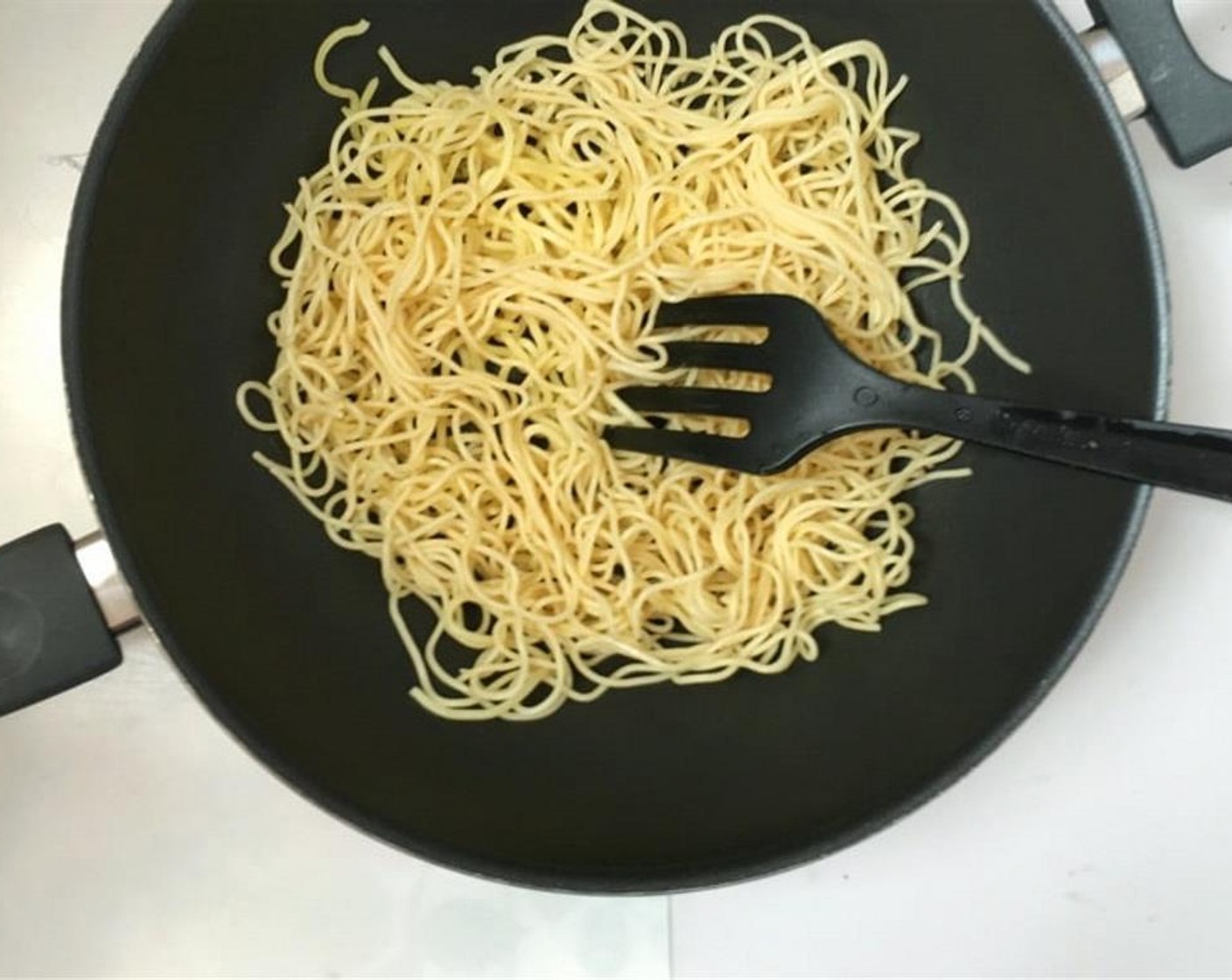 step 2 Pour half of the Vegetable Oil (1 1/2 Tbsp) in a large wok and place it over high heat. Once the oil is hot, add the cooked Egg Noodles (8 oz) and fry for a couple of minutes until they start to crisp up lightly. Transfer the noodles to a plate.