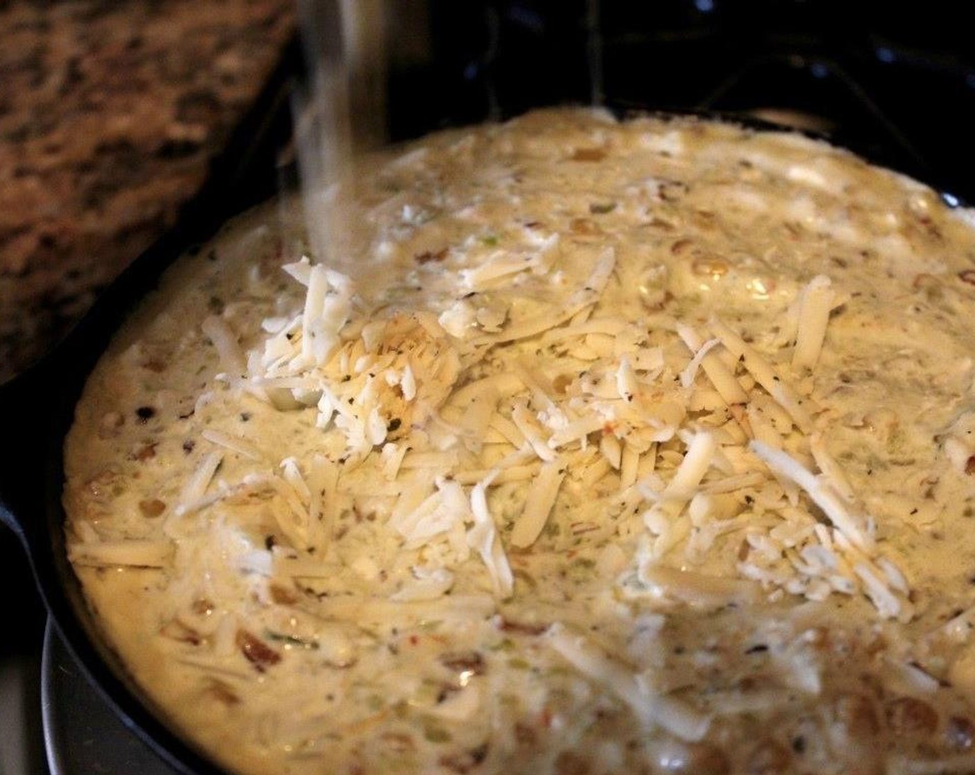 step 5 Pour the combined dip back into the hot skillet, and top with the remaining shredded cheese.