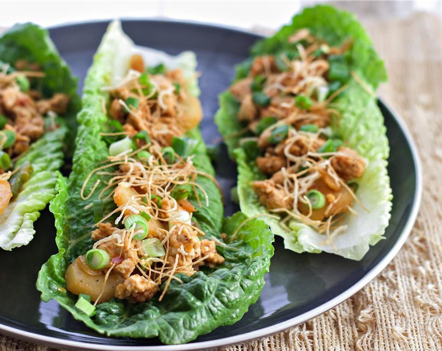 step 7 Separate the leaves from the Romaine Lettuce (2 heads) and wash. Dry using a salad spinner or paper towels. assemble the wraps,  top the pieces of lettuce with the filling, Scallion (1 bunch) and maifun noodles.