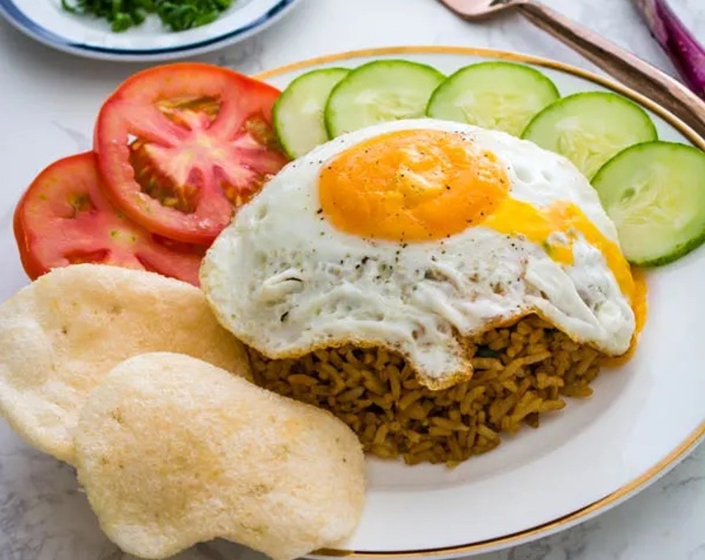 step 7 Place fried egg over the rice. Garnish with Tomatoes (as needed), Cucumbers (as needed), and Shrimp Crackers (as needed). Enjoy!