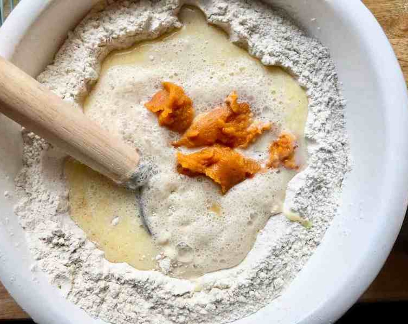 step 5 Make a well in the center of the flour mixture, then add the yeast mixture, milk mixture, Canned Pumpkin Purée (1 cup), and Eggs (2). Stir until a soft, batterlike dough forms, 1 to 2 minutes.