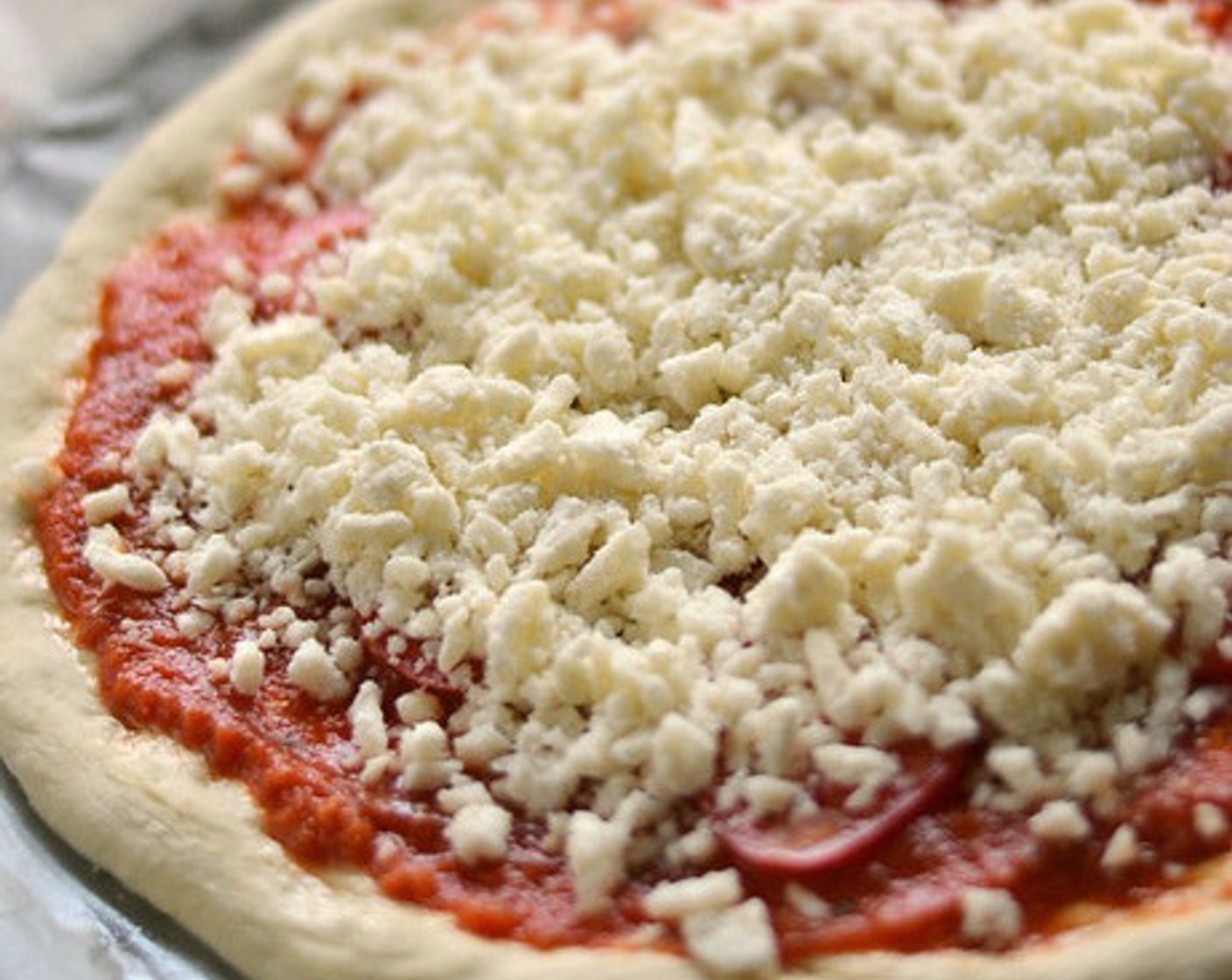 step 4 Add the Tomato Sauce (1 cup), Tomato (1), Shredded Mozzarella Cheese (2 cups), and any additional herbs to the top of the dough, if desired.