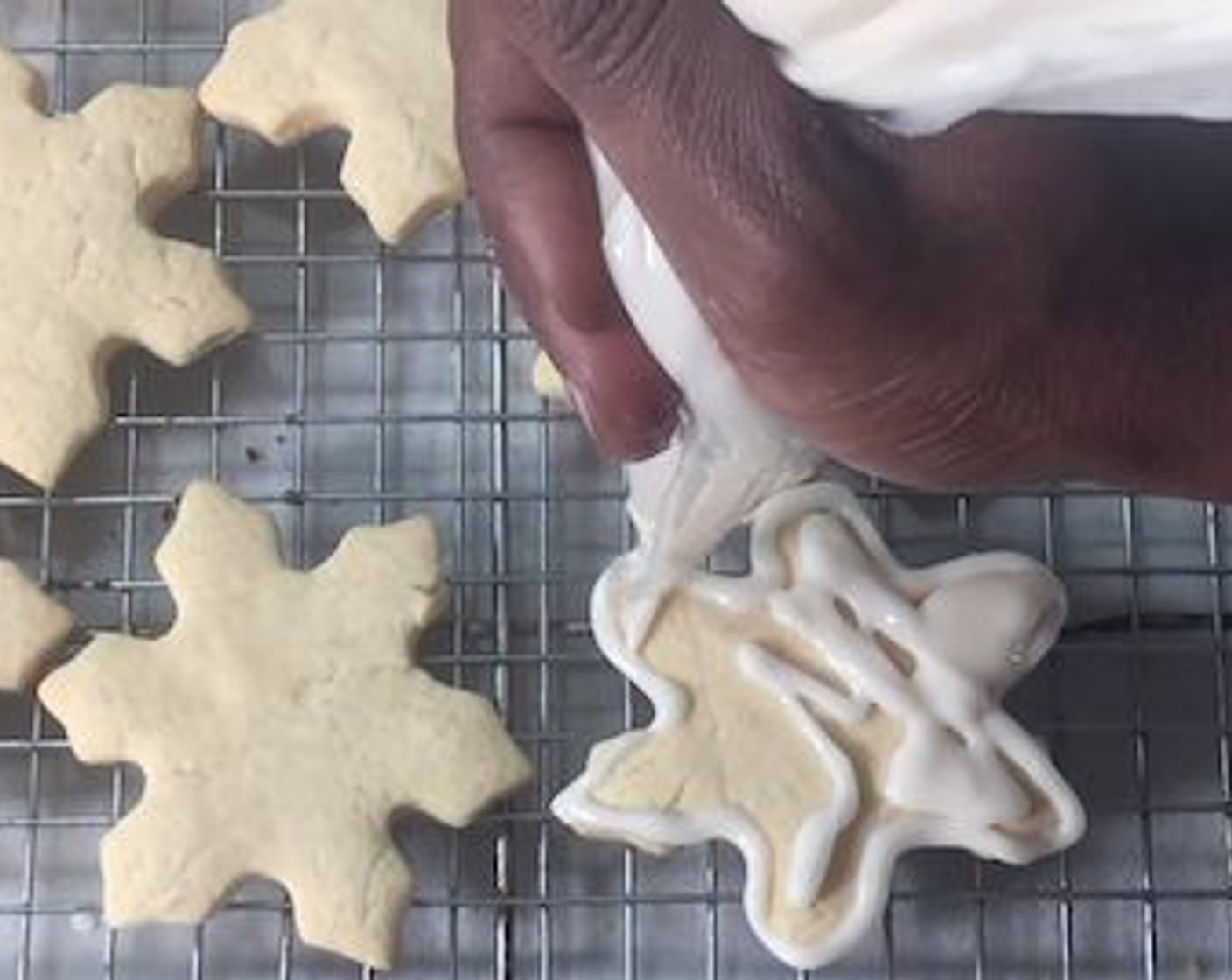 step 13 Fill a piping back with the frosting and frost the cookies to your liking. Using an airbrush machine, color the cookies once the frosting has dried.