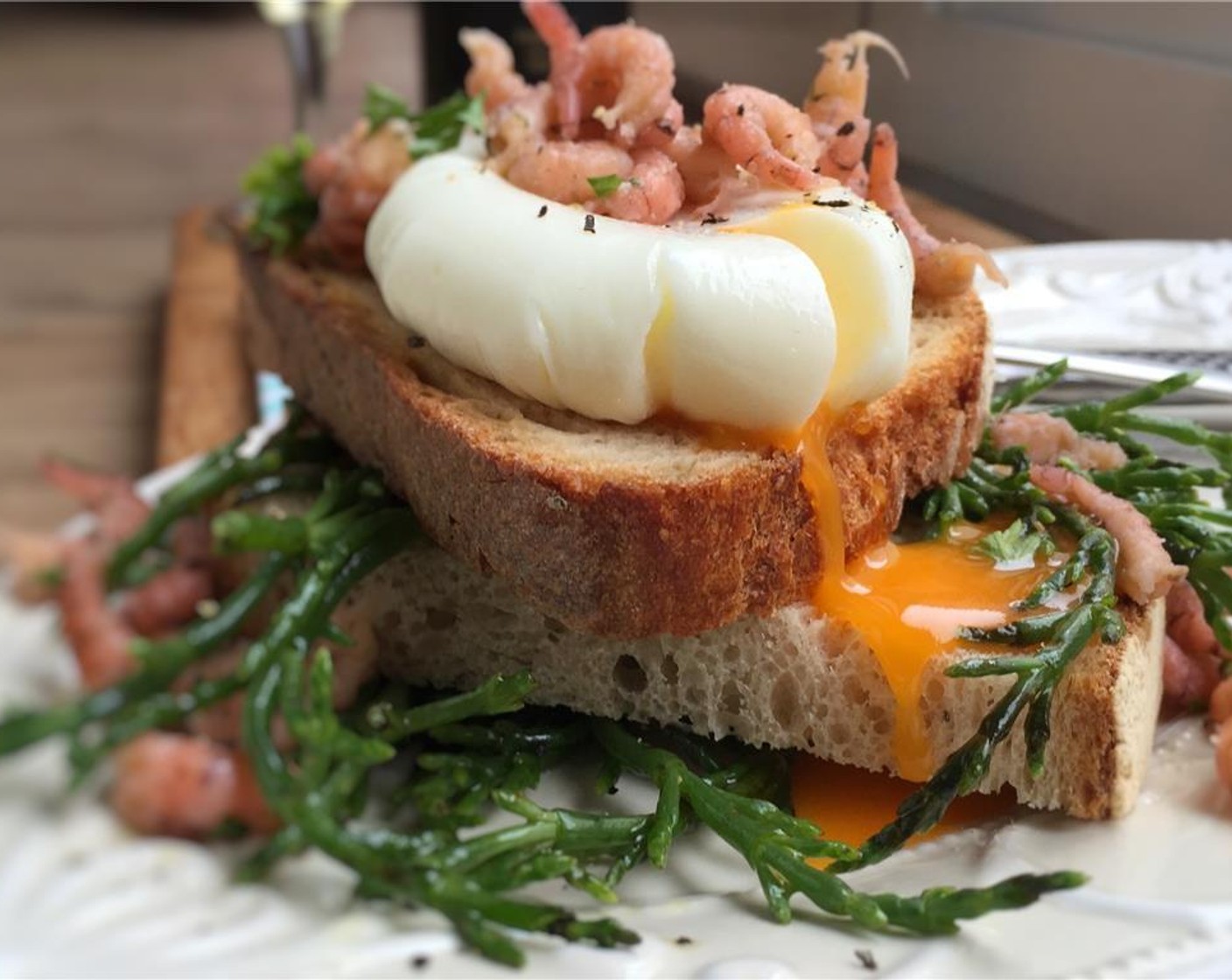 step 9 Pull the cling film from under the poached egg and discard it. Now gently scoop up the egg with a tablespoon and flip it over very gently on a clean plate, a salad or a piece of toast. Sprinkle with Salt (to taste) and Ground Black Pepper (to taste), and serve immediately. Enjoy!