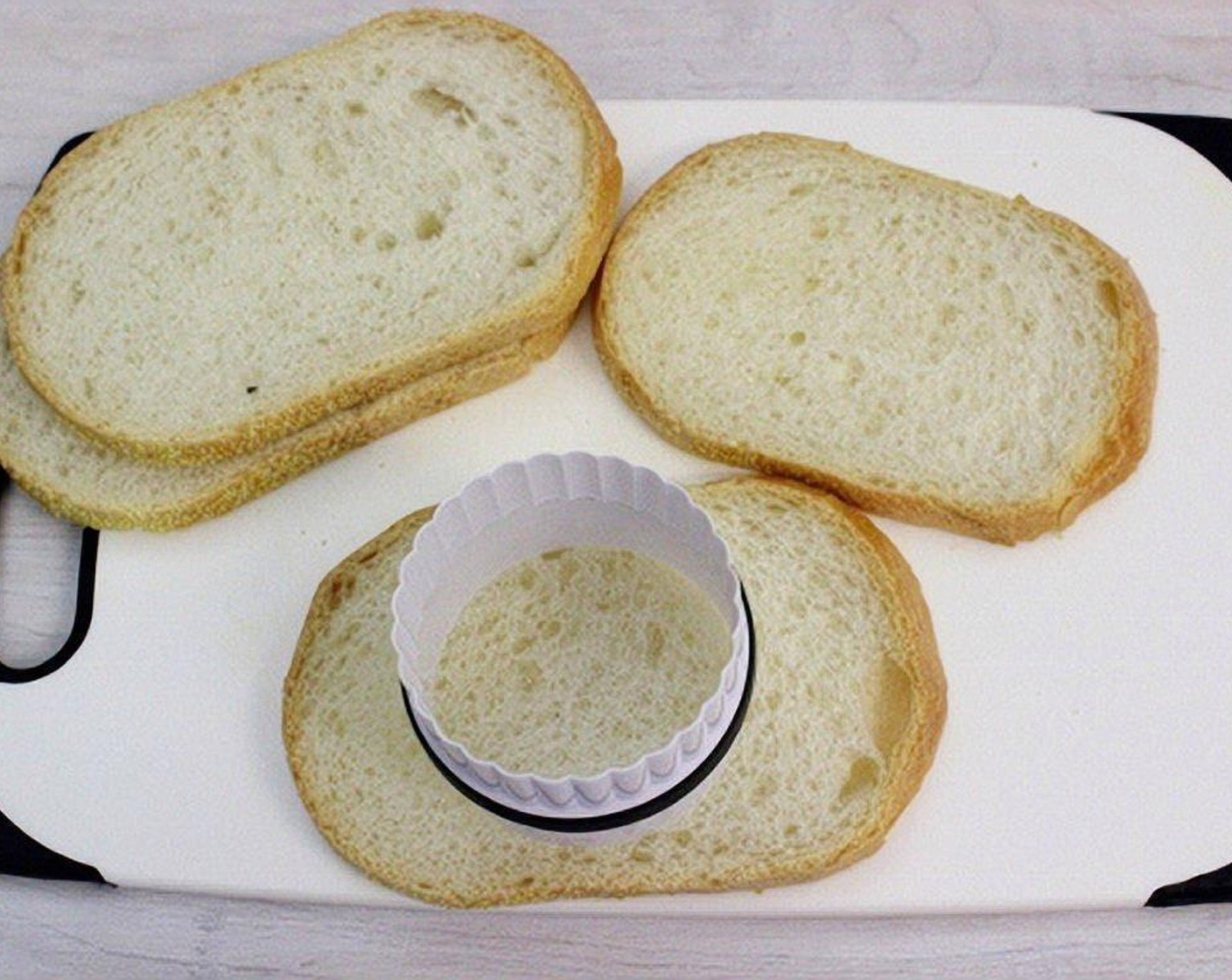 step 2 Cut out a hole from the center of each Bread (4 slices). You can use a biscuit cutter or simply scissors and knife.