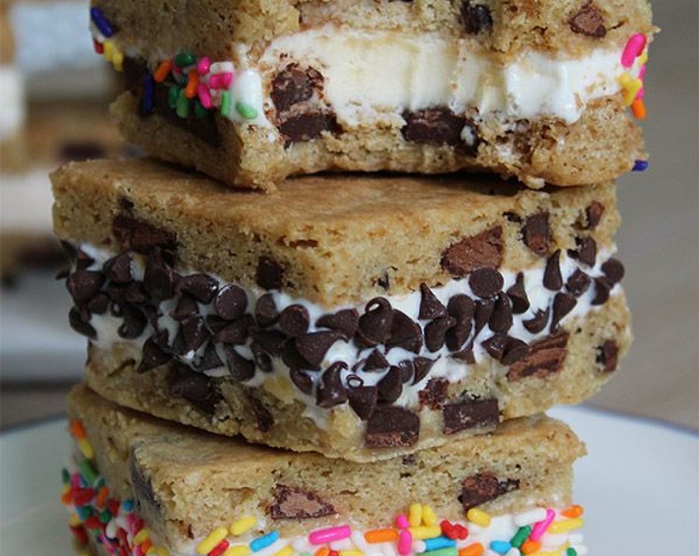 step 8 Using a sharp knife, carefully trim about ¼-inch from each edge of the giant cookie sandwich, then cut it into 12 individual sandwiches. Place Mini Chocolate Chips (to taste) and Sprinkles (to taste) on small plates and press each side of the sandwiches into so the toppings adhere. Place all the decorated sandwiches back on the platter, freeze until firm, then serve or wrap individually with wax paper.