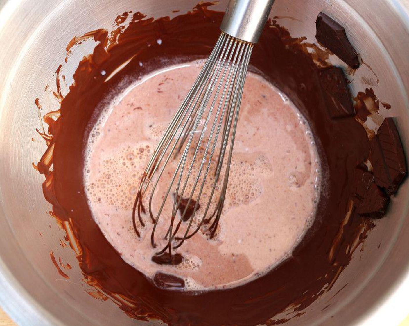 step 2 Pour the hot milk over the chocolate and leave it to sit for 1 to 2 minutes. Stir with a spatula or a wooden spoon until you have a smooth ganache.