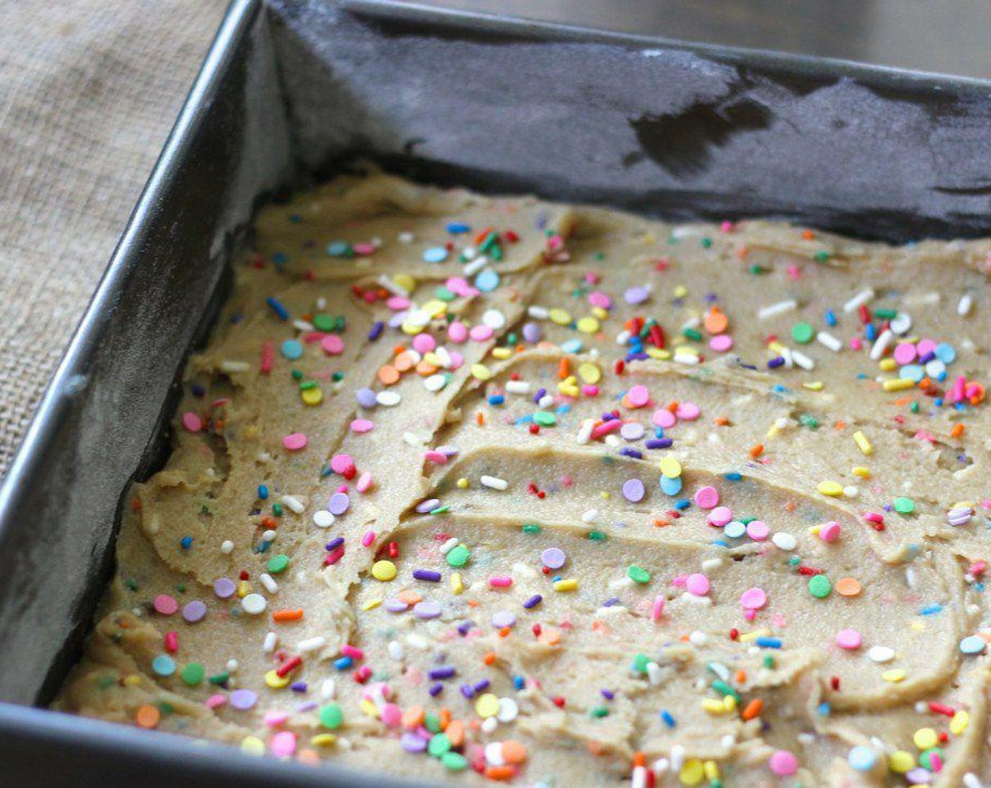 step 4 Evenly spread batter in the greased pan and sprinkle the rest of the Sprinkles (1 Tbsp) on top.