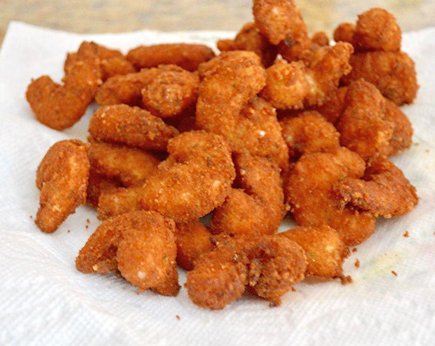 step 7 When the shrimp is set, fry them in batches of about 8. They will only take about 2-3 minutes to fry to perfection. Fish them out with a slotted spoon or mesh strainer to a paper towel lined plate to drain.