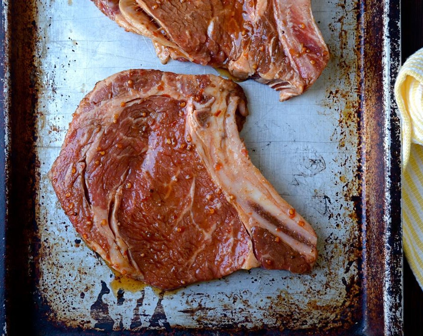 step 7 Once ready to grill, remove the steaks from the marinade and place them on a baking sheet. Pour the steak marinade into a bowl and reserve for basting. Dry the steaks off on both sides using a paper towel.