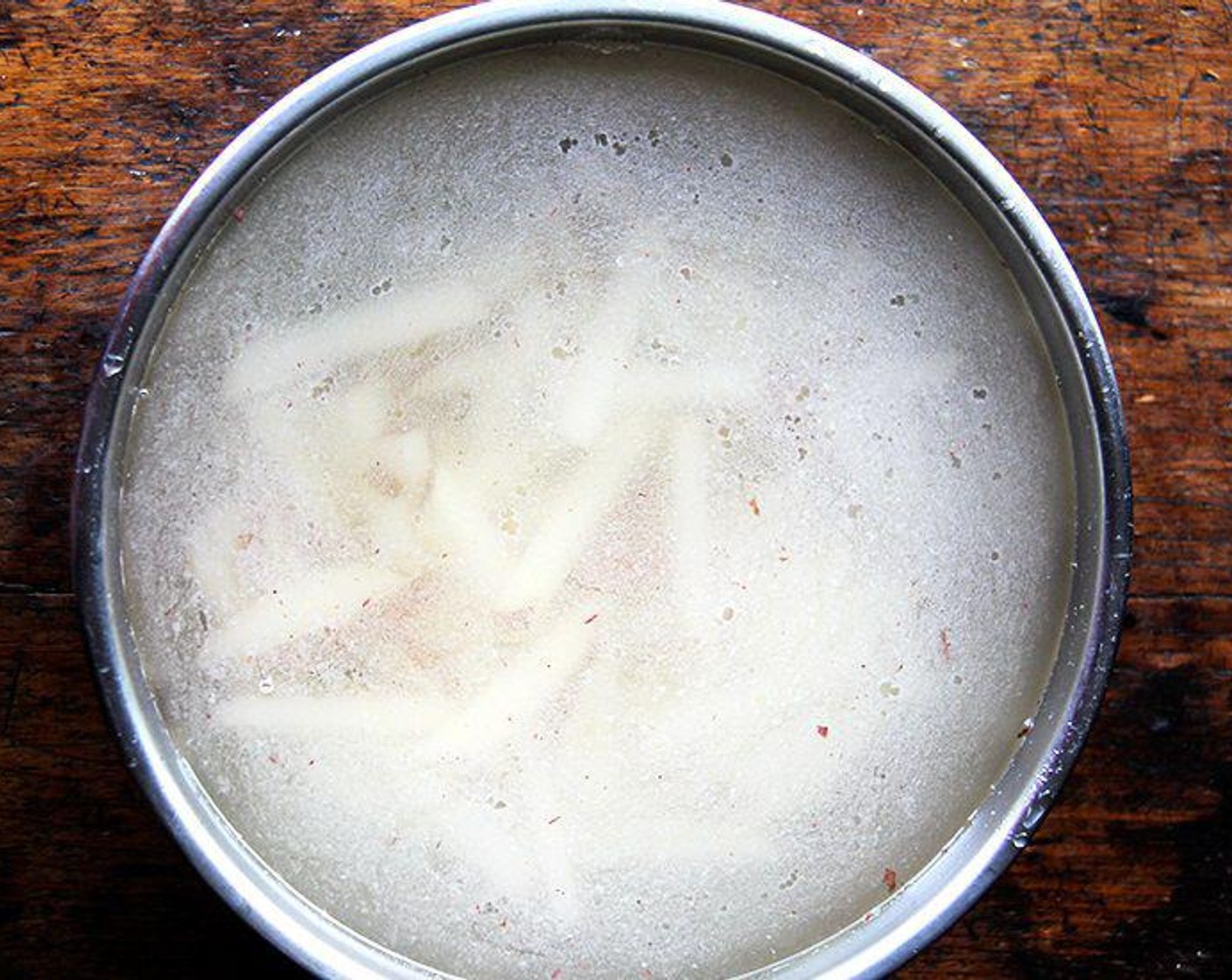 step 3 Place the sliced potatoes into a large bowl and cover them with hot tap water. Let them soak for 10 minutes.