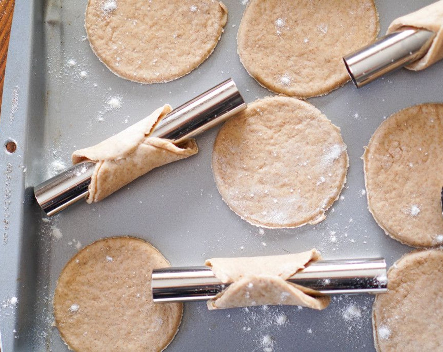 step 6 Use a 3 or 4-inch cookie cutter or bottom of a glass to cut out circles. Form a circle over a cannoli mold, using the egg white (1) to seal the edge. If the dough is pulling away from the mold, give it a gentle roll with the rolling pin to make it bigger to shape over the mold.