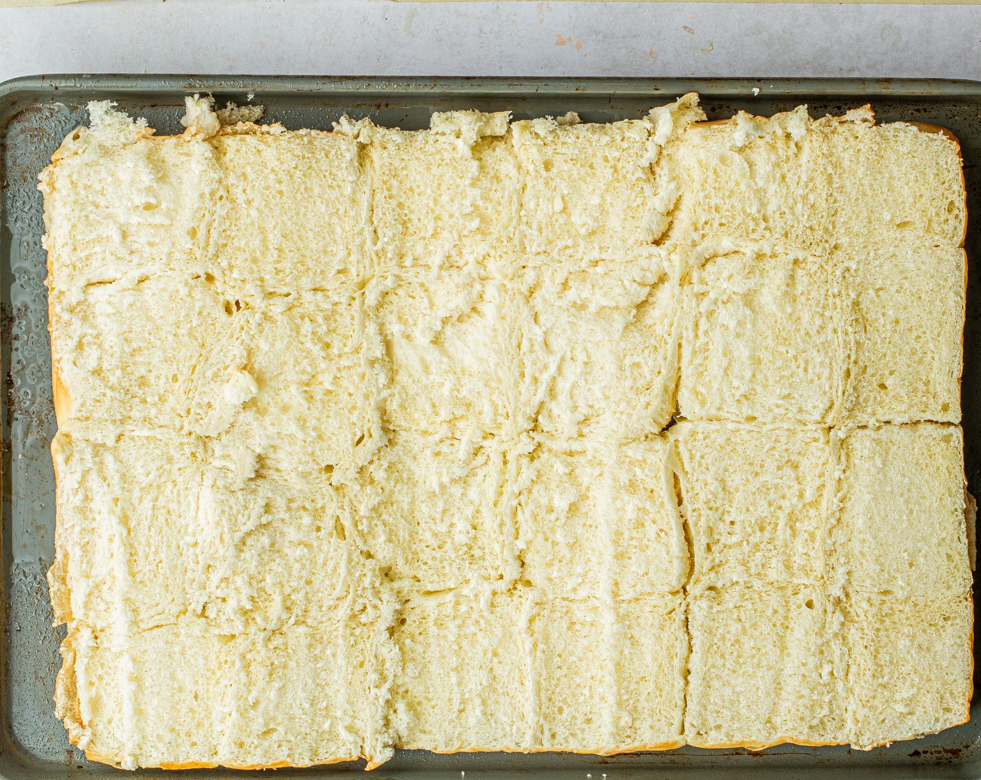 step 7 Using a serrated knife, cut the Slider Buns (24) through the middle leaving individual rolls attached. Place the bottom buns (cut side up) on a sheet pan. Brush both sides with melted butter reserving some for the top.