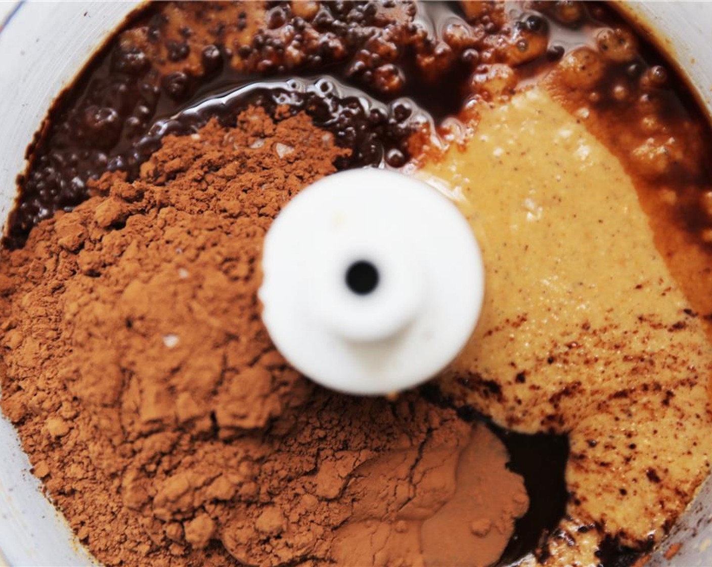 step 6 Once the hazelnut butter is smooth and creamy, add the  Unsweetened Cocoa Powder (4 Tbsp), Pure Vanilla Extract (1 tsp), Honey (2 Tbsp) and Sea Salt (1/2 tsp) and continue blending until smooth and creamy.