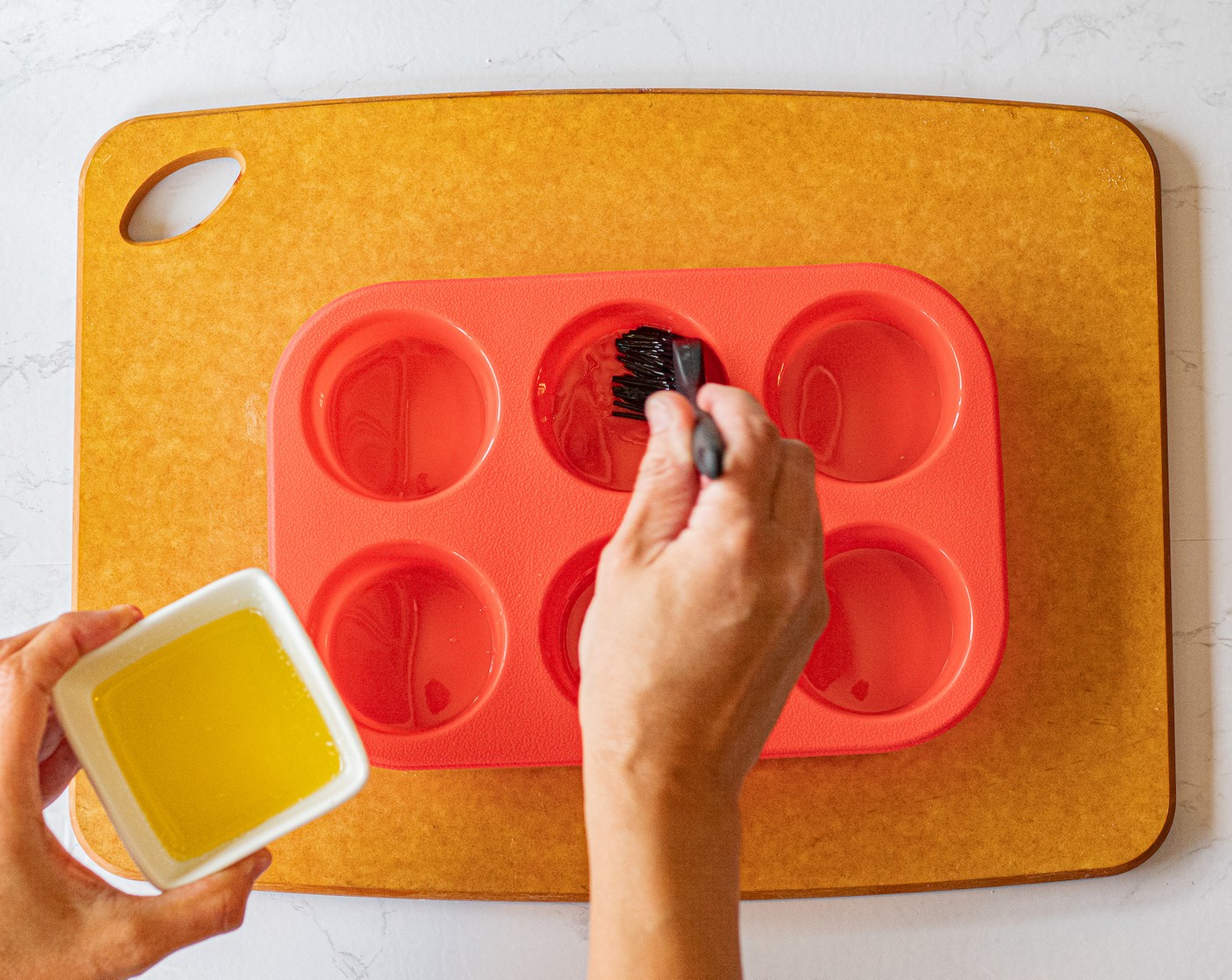 step 7 Use some of the melted butter to brush each hole in a muffin tin.