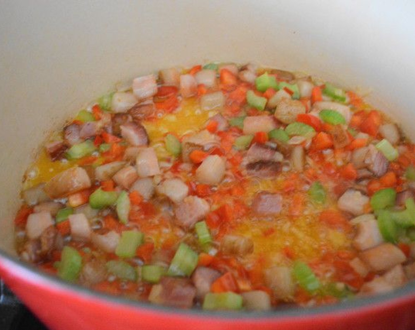 step 2 Once that is done, add the Onion (1/2), Red Bell Pepper (1/2), and Celery (1 stalk). Let them get soft and fragrant for a minute or two.